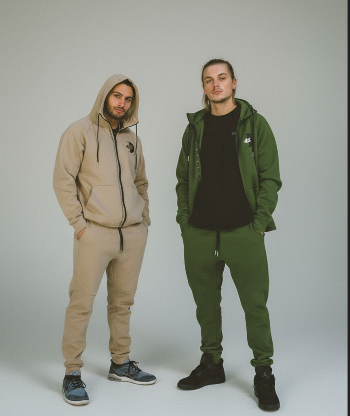 Two men wearing matching tracksuits in beige and green on a plain background