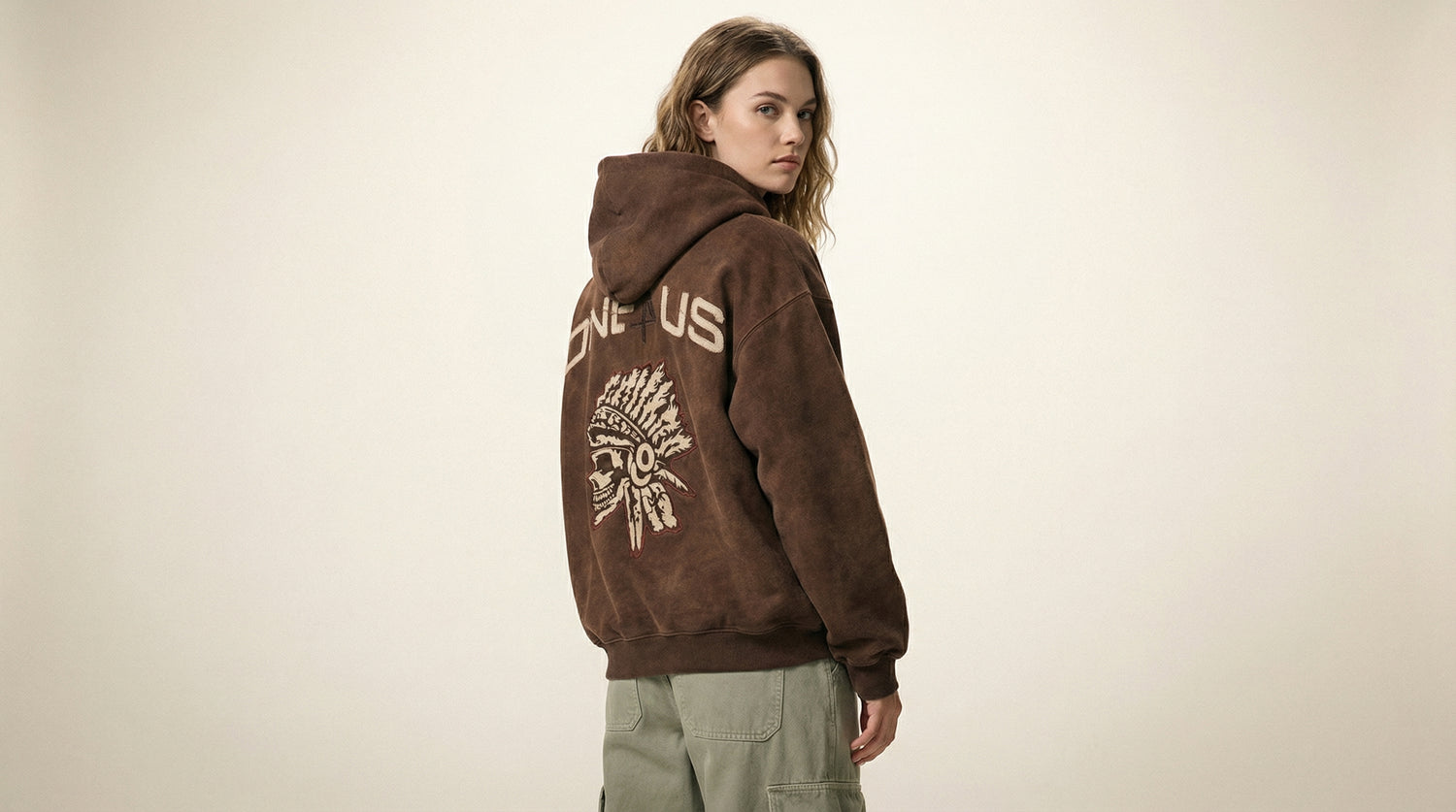 Catalog woman wearing a brown hoodie with text and graphics on a beige background