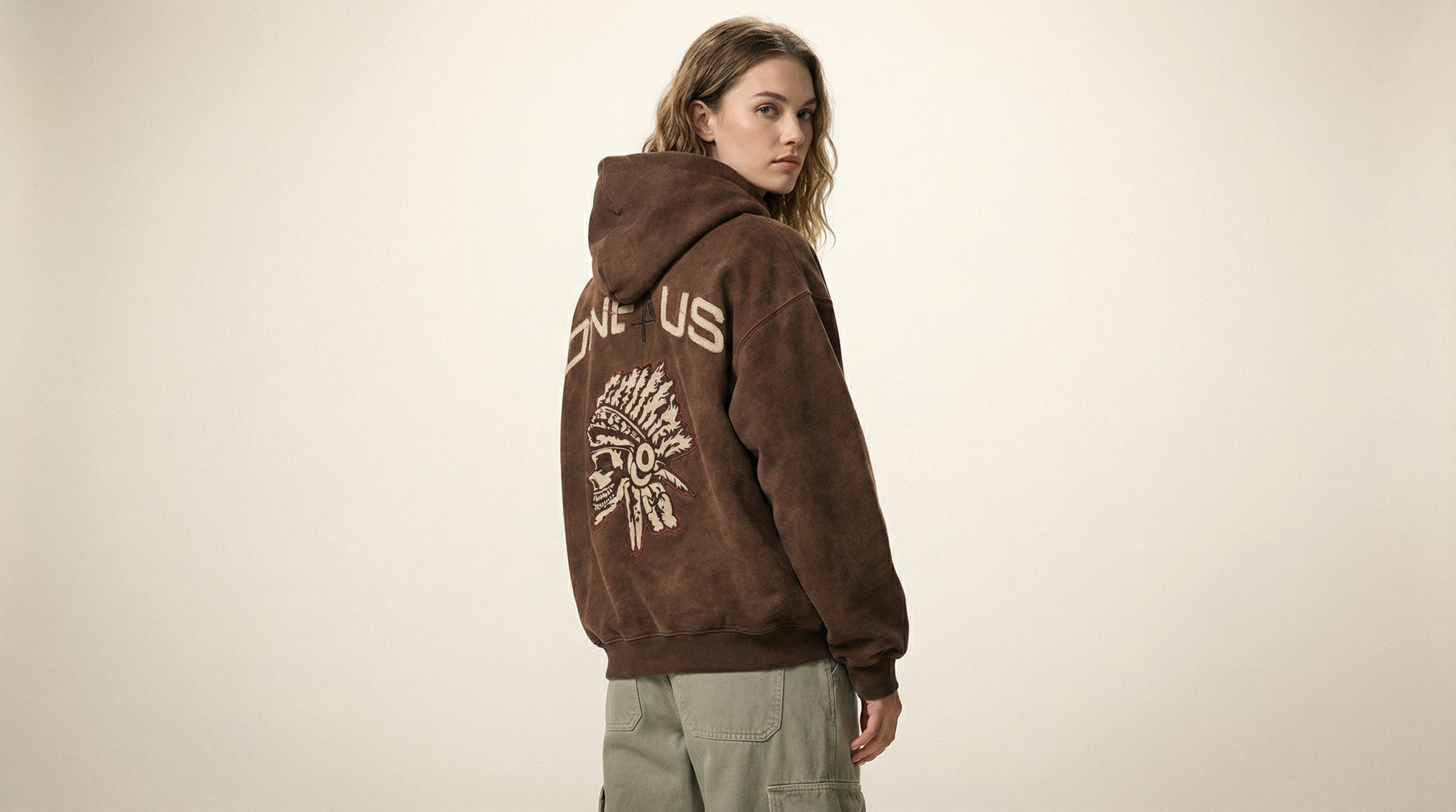 Catalog woman wearing a brown hoodie with text and graphics on a beige background