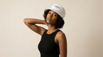 Catalog woman wearing a white cap with branding on a beige background