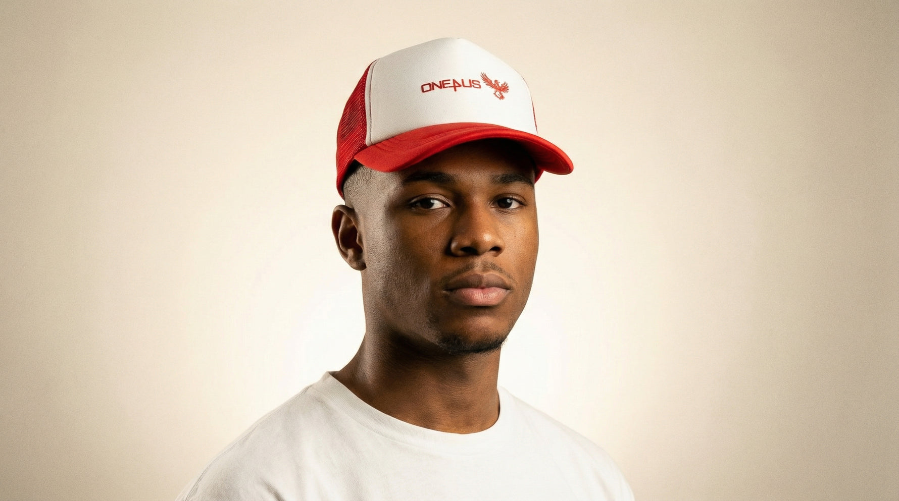 Catalog man wearing a red and white cap with 'One4Us' branding on a beige background