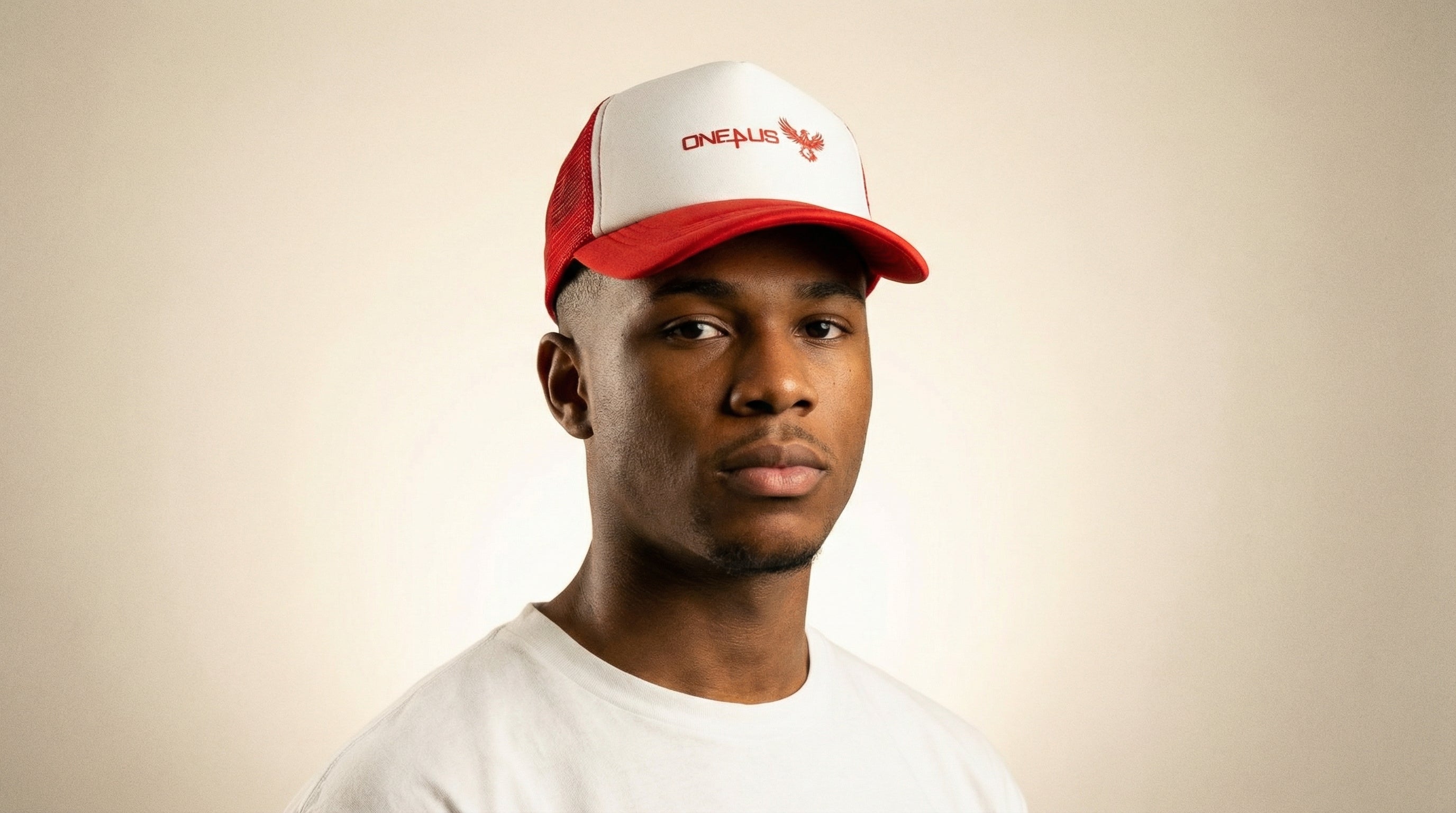 Catalog man wearing a red and white cap with 'One4Us' branding on a beige background