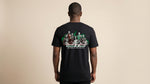 Catalog man wearing a black t-shirt with 'League of First' graphics on the back against a beige background