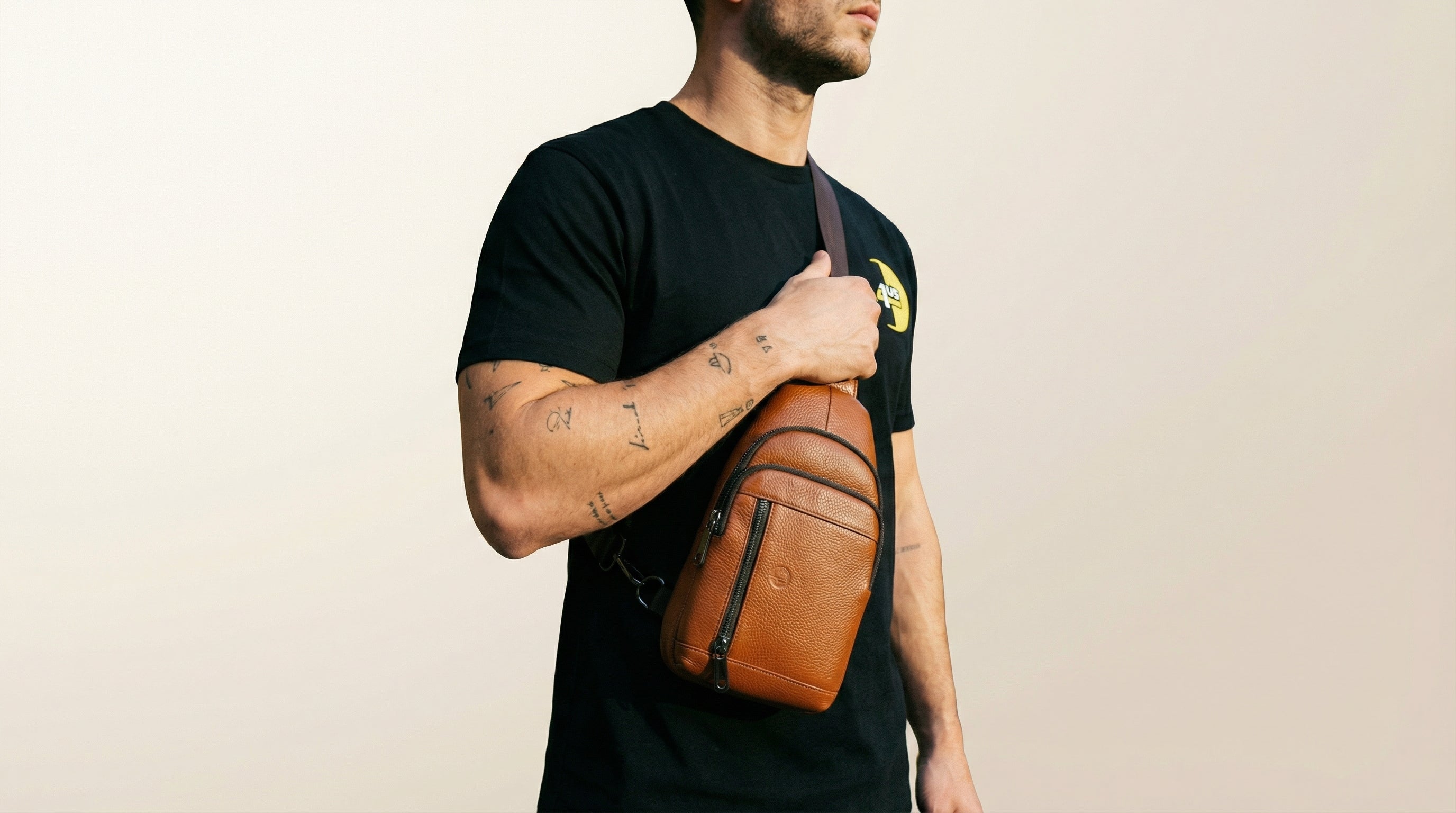 Catalog man holding a brown leather bag against a beige background