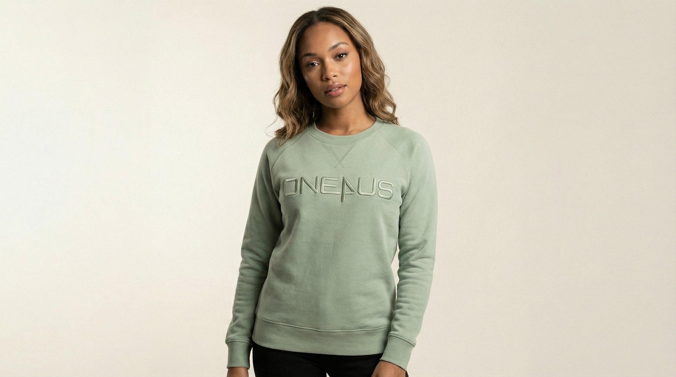 Catalog woman wearing a green sweatshirt with 'One4Us' text on a beige background