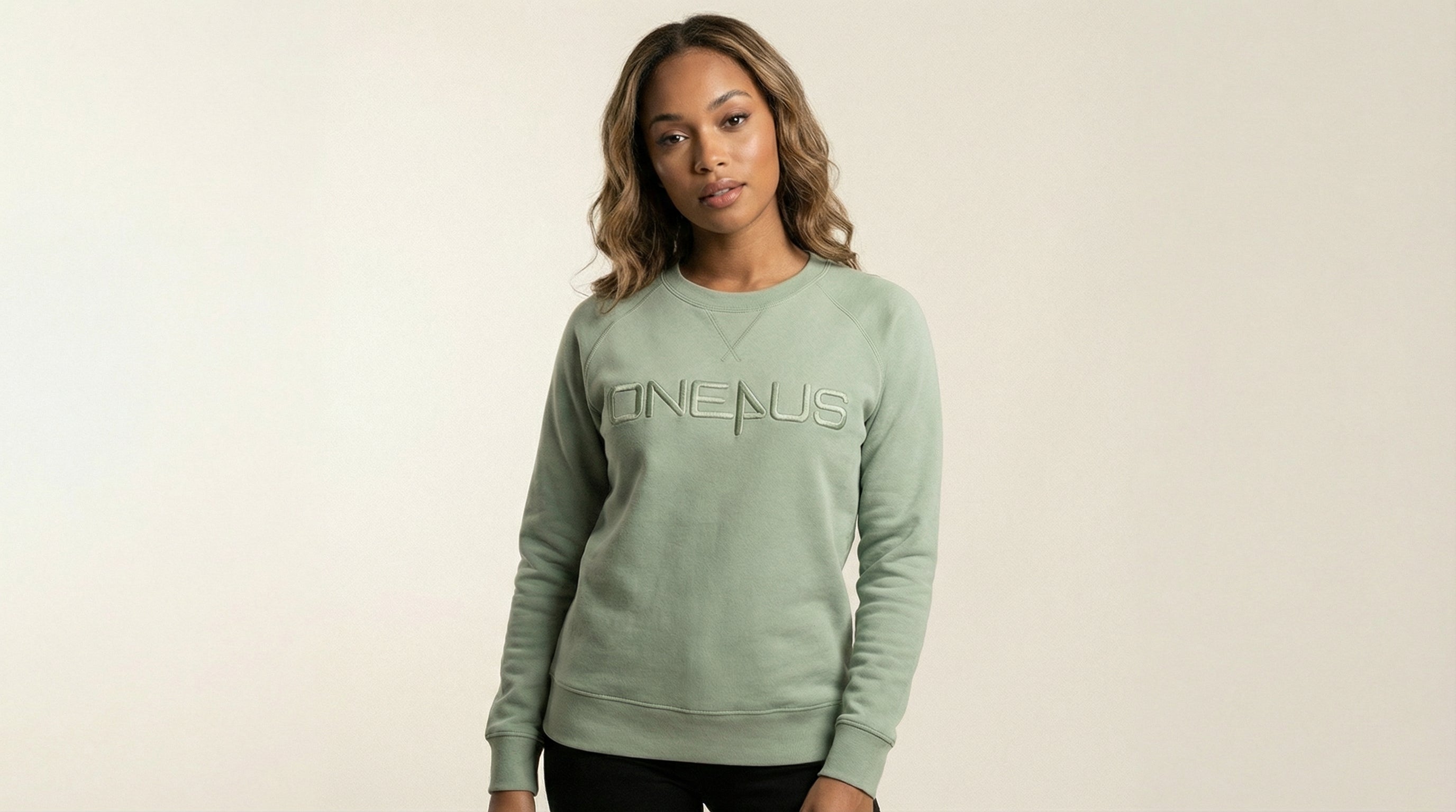 Catalog woman wearing a green sweatshirt with 'One4Us' text on a beige background